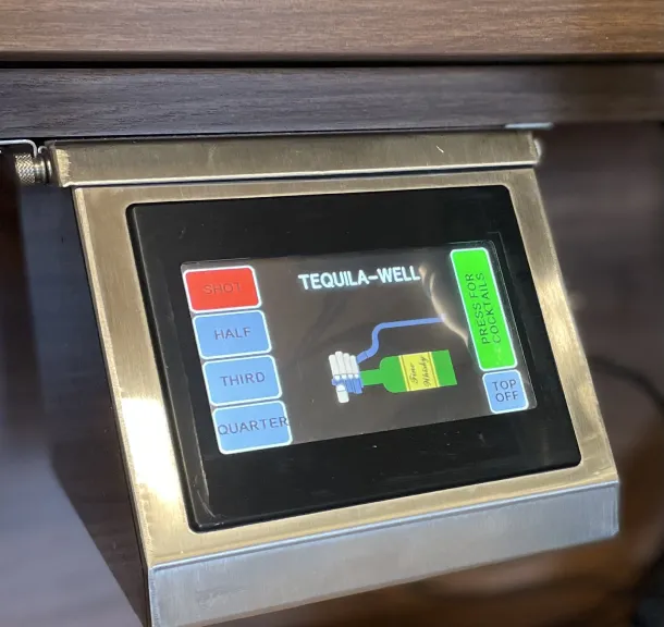 Touchscreen tequila well liquor pour control system panel mounted at a resort bar.